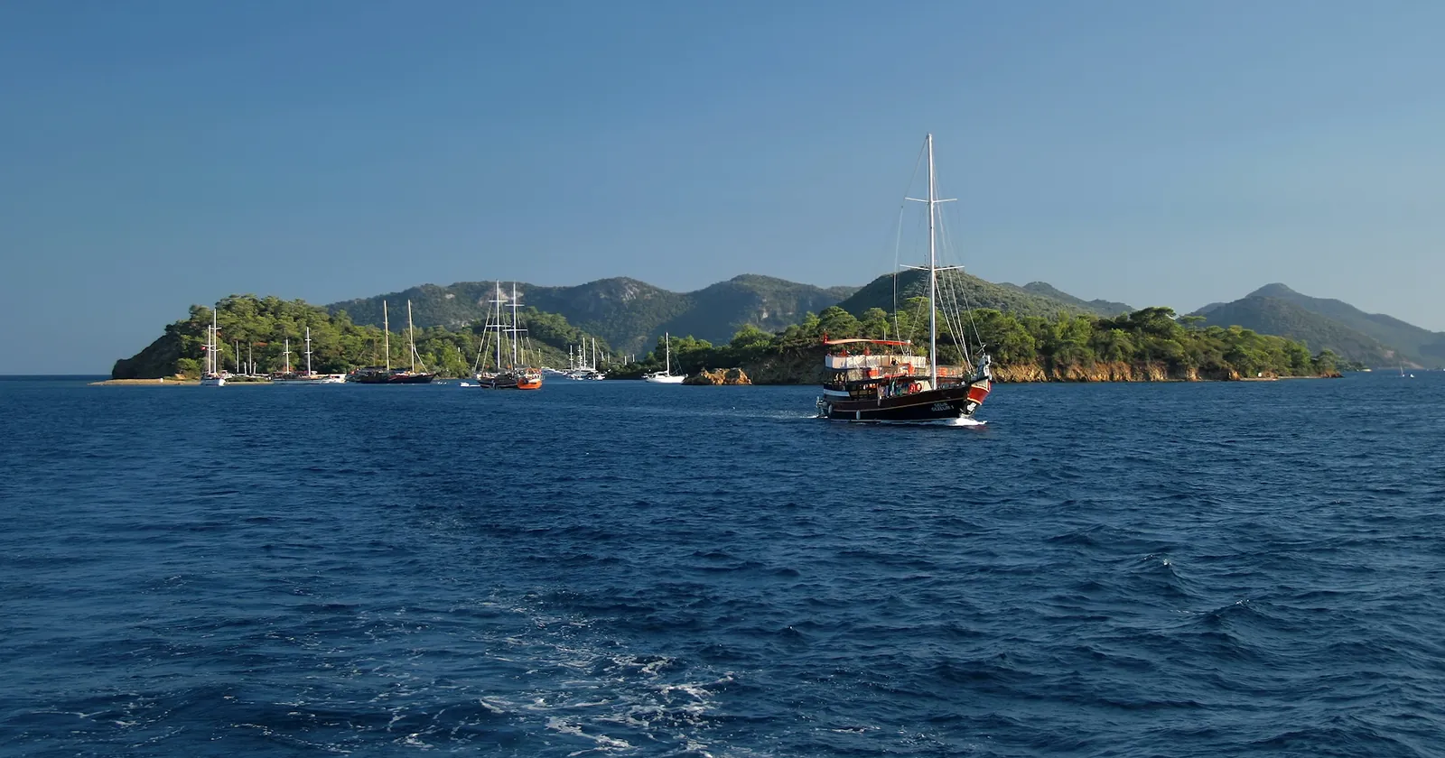 A gulet passing the wooded Yassıca Islands in the Gulf of Fethiye, among the Twelve Islands