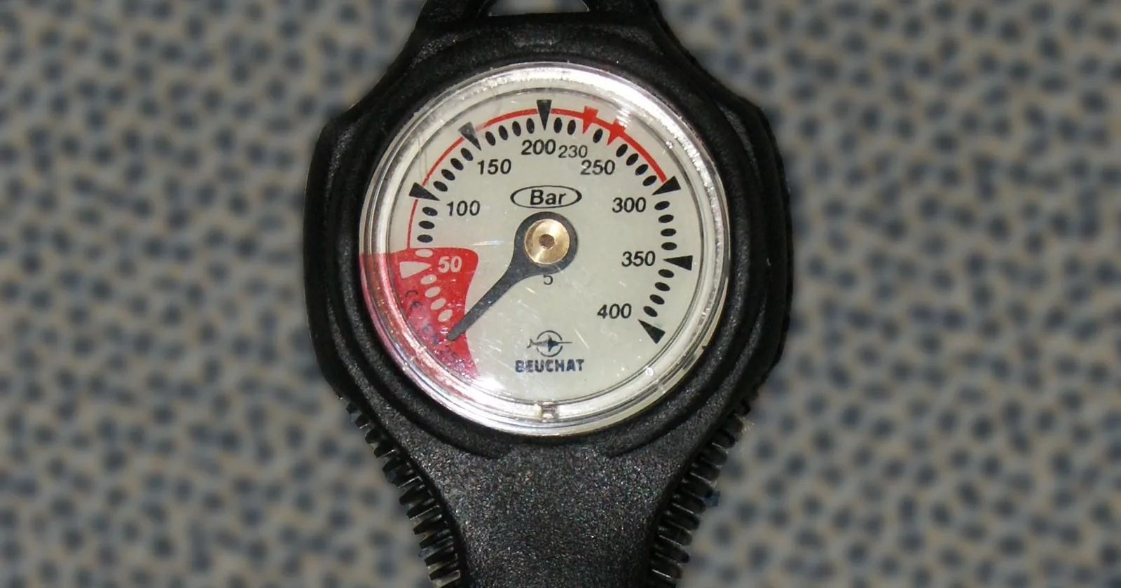 Analog submersible pressure gauge reading in bar, the tank gauge an Apple Watch Ultra diver still needs