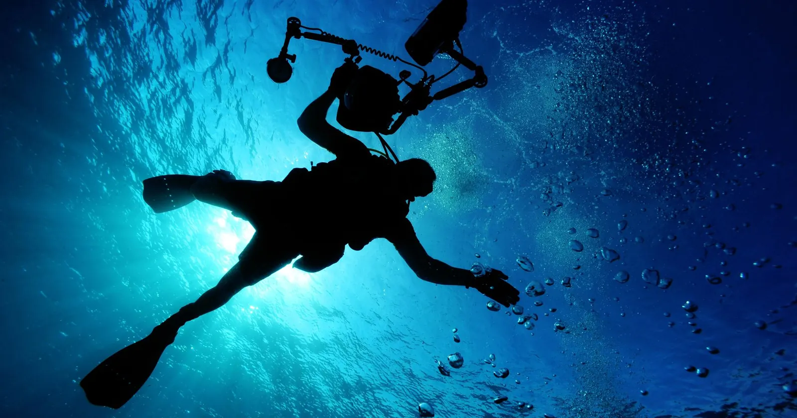 Diver filming a reef with an underwater camera