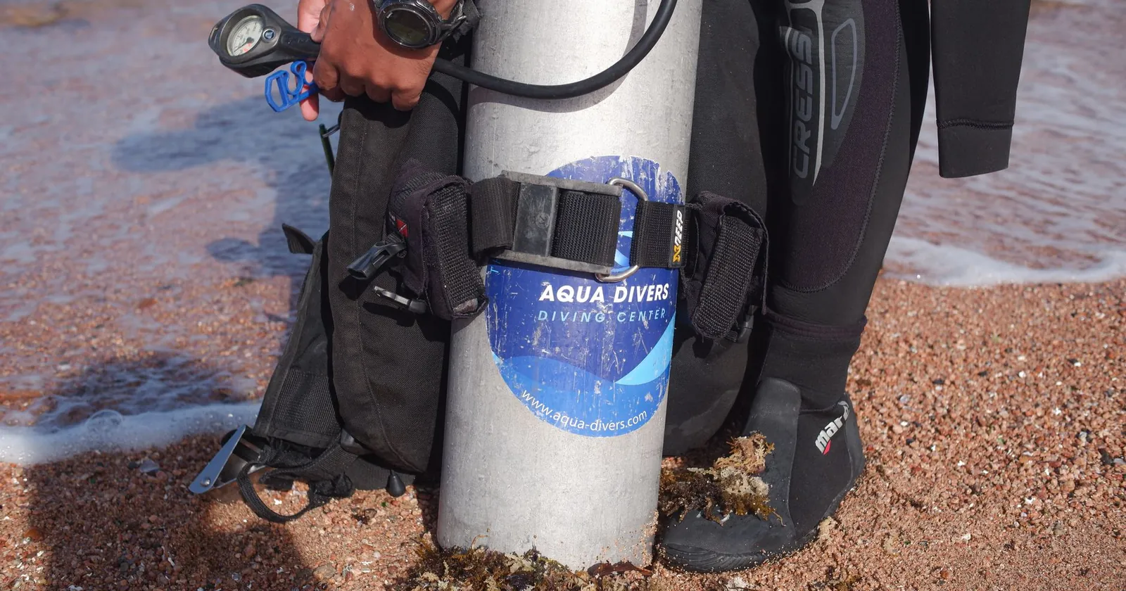 Diver in a wetsuit with mask, fins and wrist computer, the personal travel kit