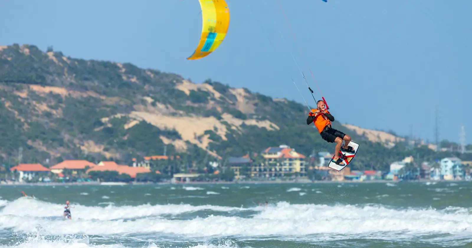A kitesurfer skillfully maneuvers through ocean waves on a s