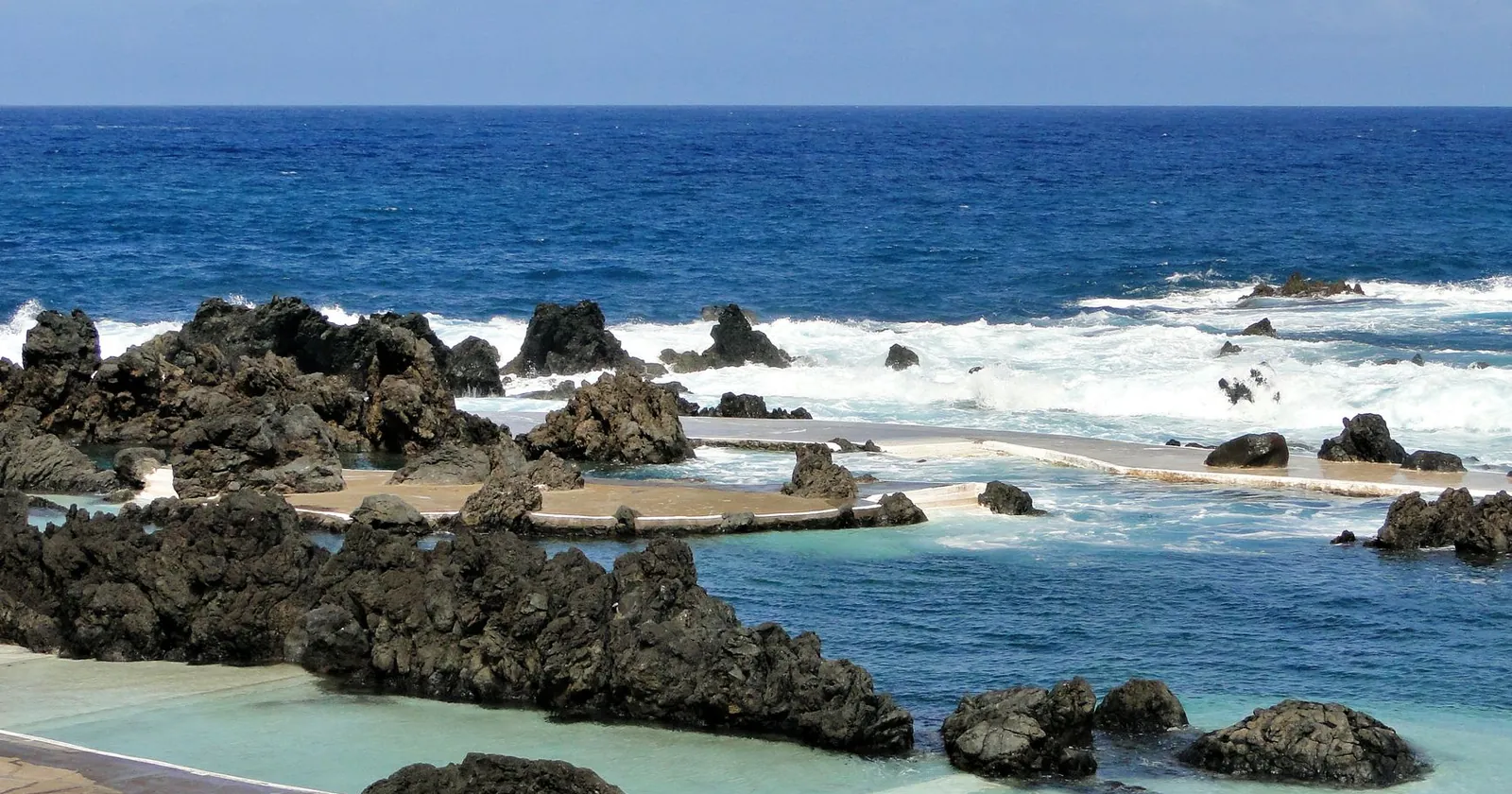 Swimmer in a clear natural pool surrounded by rock