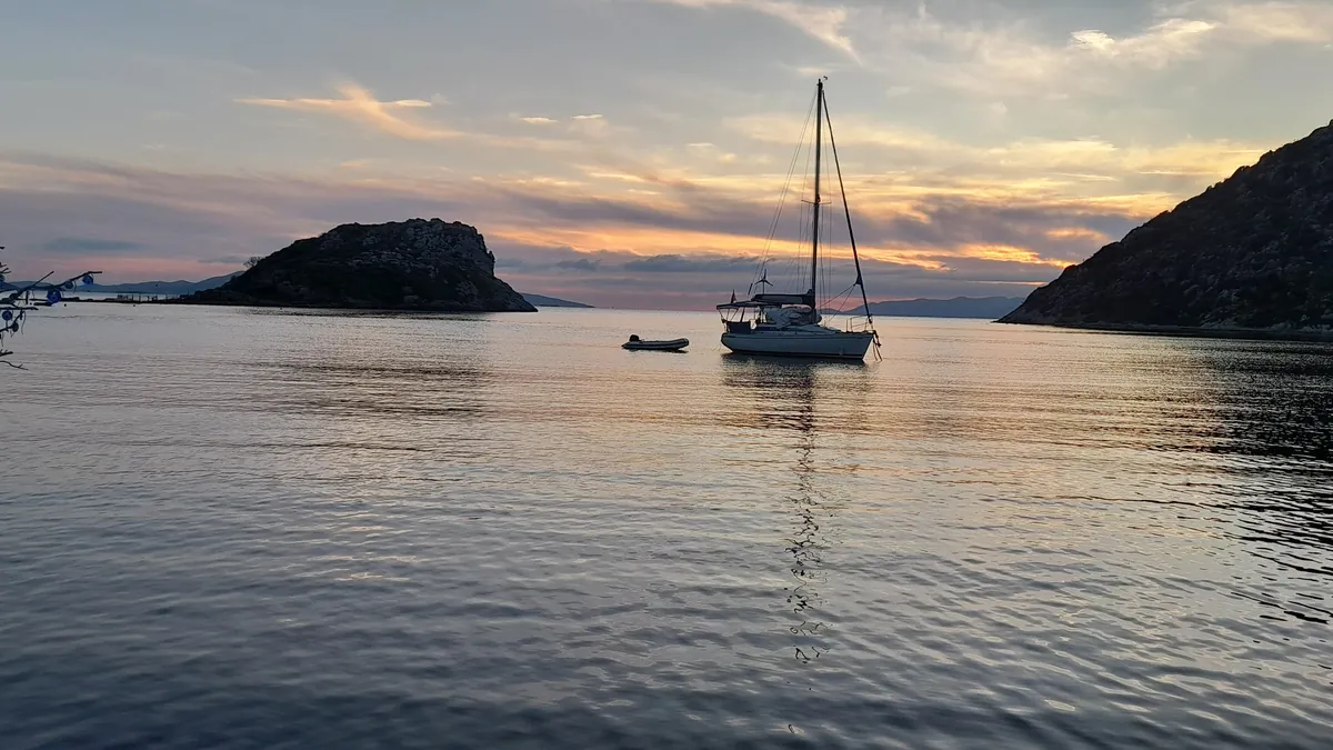 A sailing yacht at anchor in Gümüşlük bay at dusk on the west coast of the Bodrum peninsula, the stretch of coast where Bodrum diving meets closed box E28