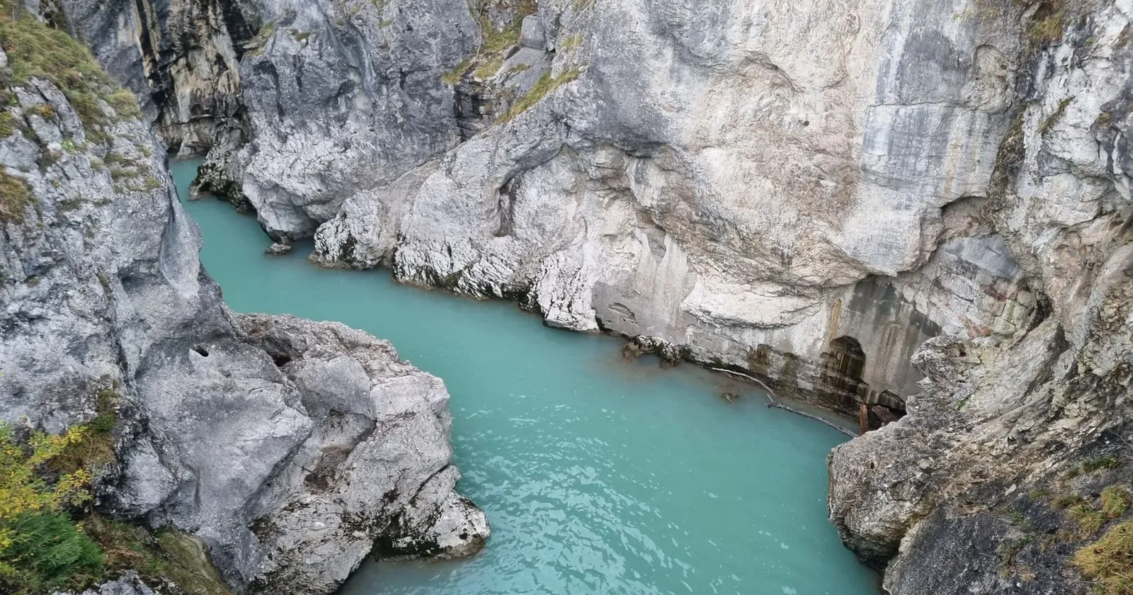 Canyoning group in wetsuits and helmets in a gorge pool