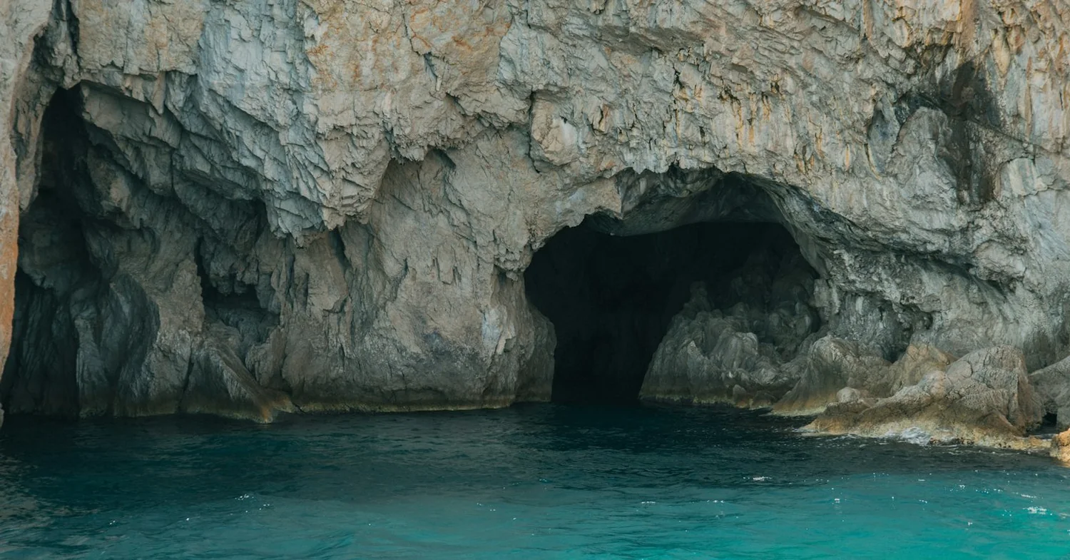 Limestone headlands and sea caves dropping into clear water on the west coast of an Ionian island