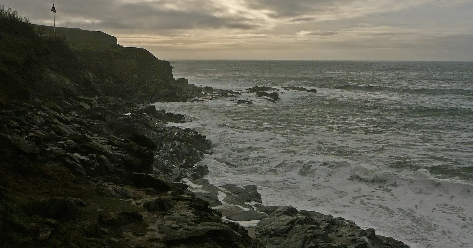 Dark rocks and breaking surf at Gunwalloe Fishing Cove on the Lizard, where two protected wrecks lie inside Cornwall diving restricted areas
