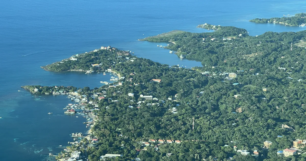 Aerial view of West End on the western tip of Roatan, with shallow water along the shore inside the Bay Islands marine park