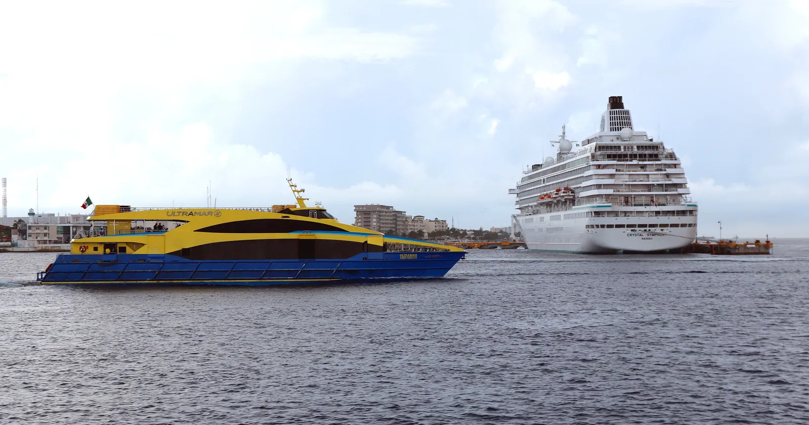 Ultramar passenger ferry to Playa del Carmen passing a docked cruise ship off San Miguel de Cozumel