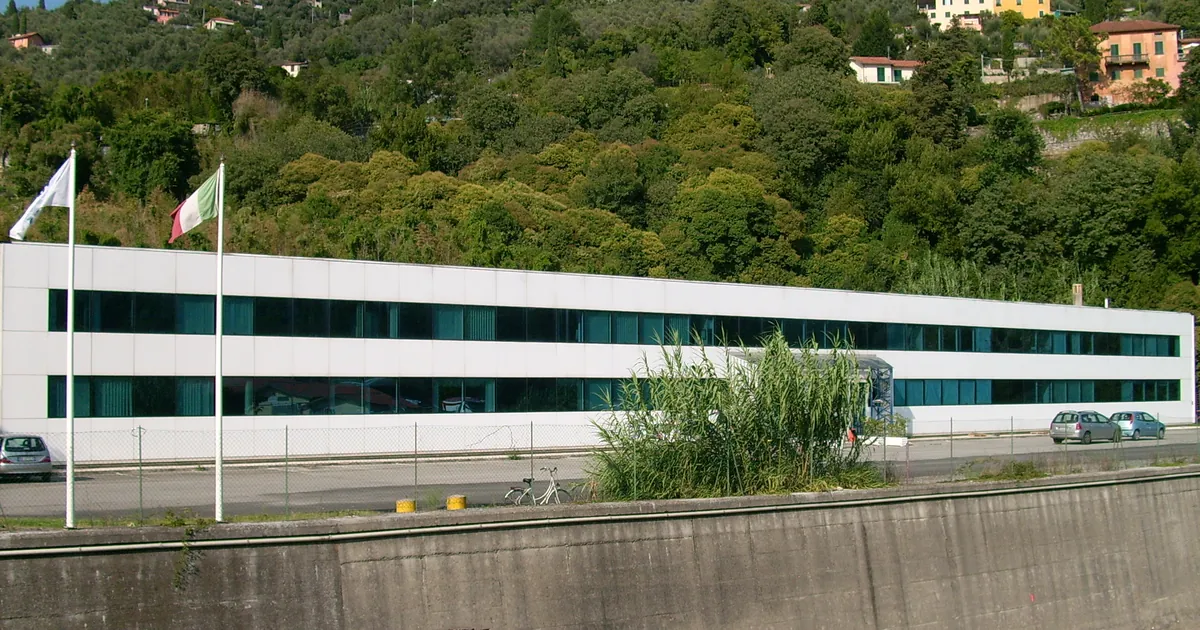 The Mares plant in Rapallo on the Ligurian coast, a long white factory building below a wooded hillside