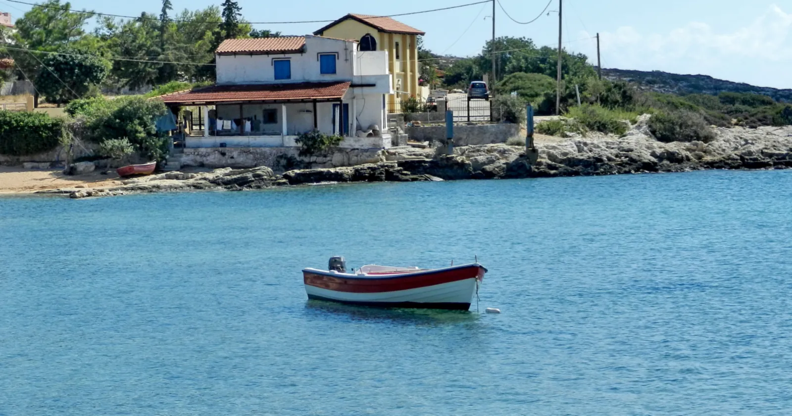 A small fishing boat moored off the rocky shore at Kato Marathi on Souda Bay, the stretch of water where the state list places the Minnewaska wreck for Crete diving
