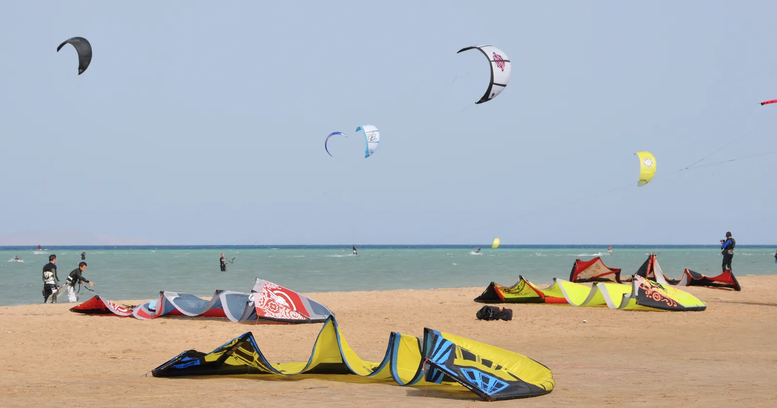 Kites in the air and laid out on the sand at Mangroovy Beach in El Gouna