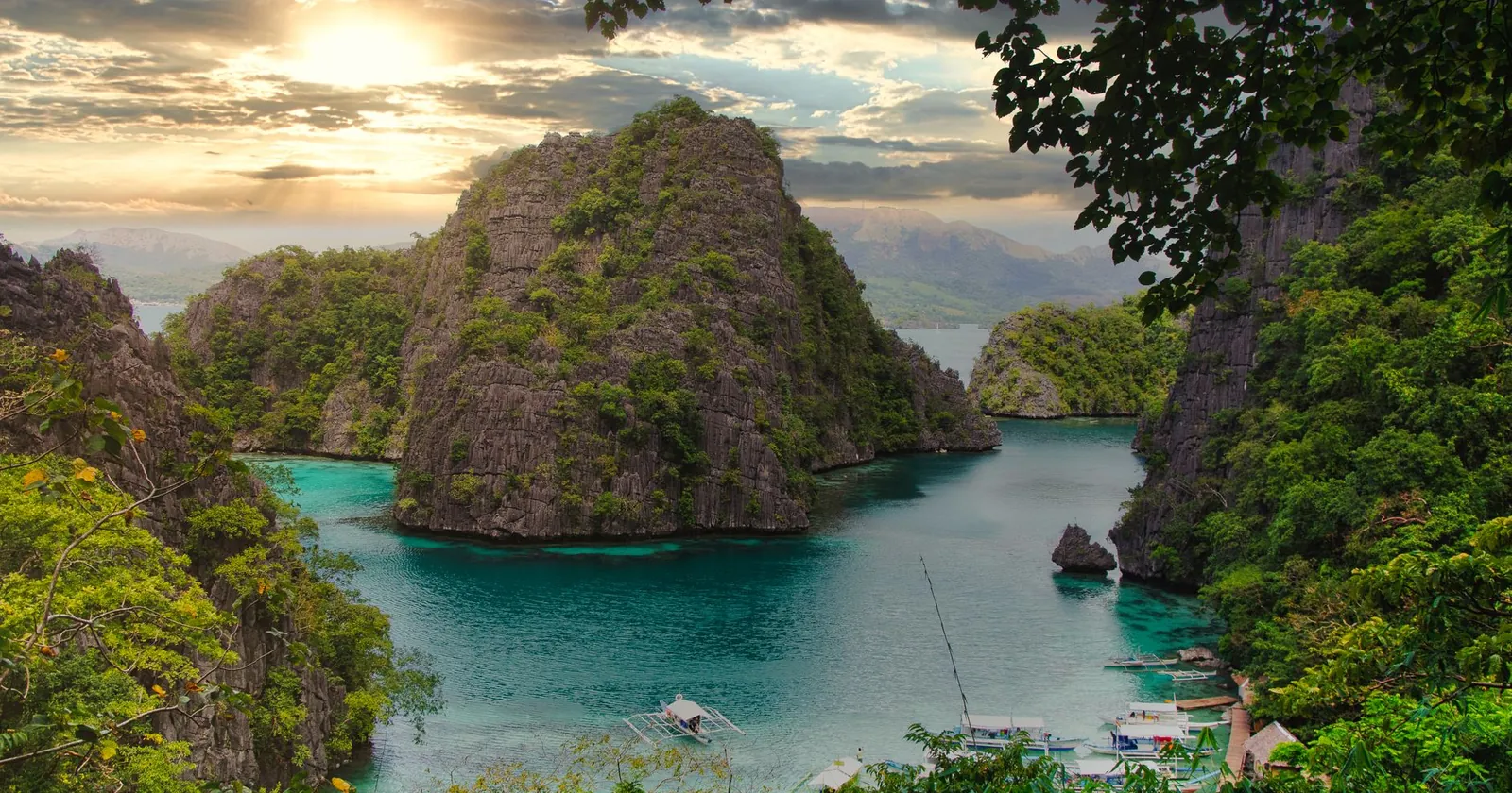 Turquoise bay with limestone islands and a boat, El Nido, Palawan