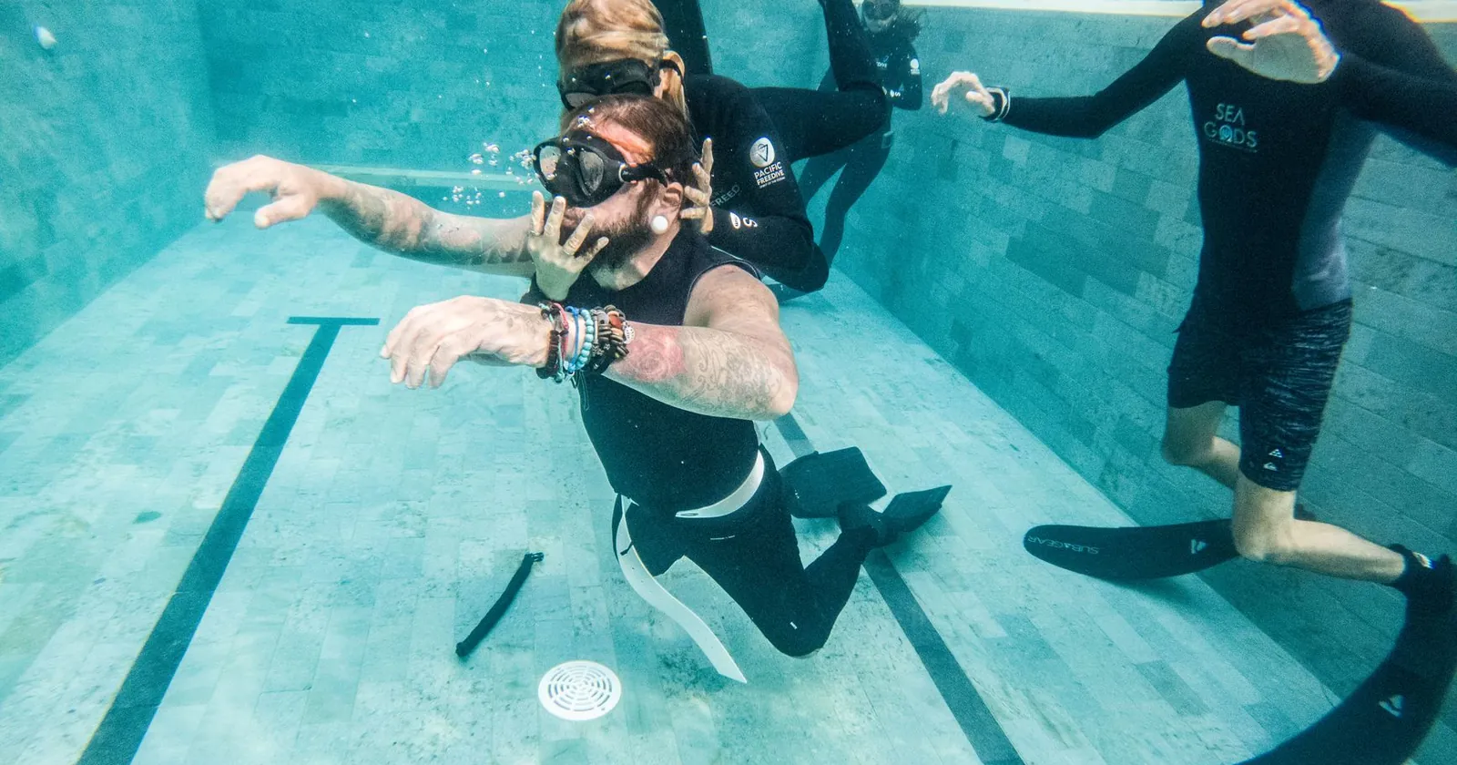 Freediver descending on a single breath in blue water