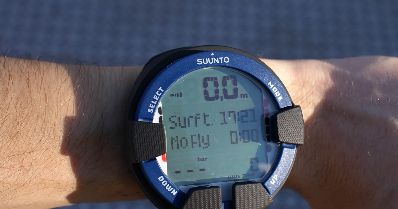 Suunto Vyper Air dive computer on a diver's wrist in surface mode, the Suunto side of the Garmin Descent vs Suunto comparison
