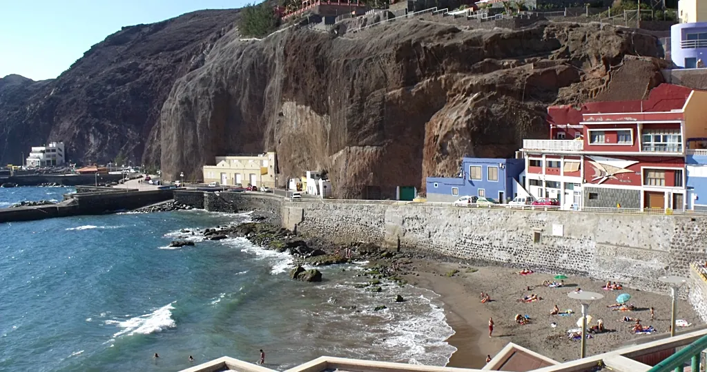 The beach, sea wall and harbor promenade at Sardina del Norte in Gáldar, the sheltered bay used for shore entries in Gran Canaria diving