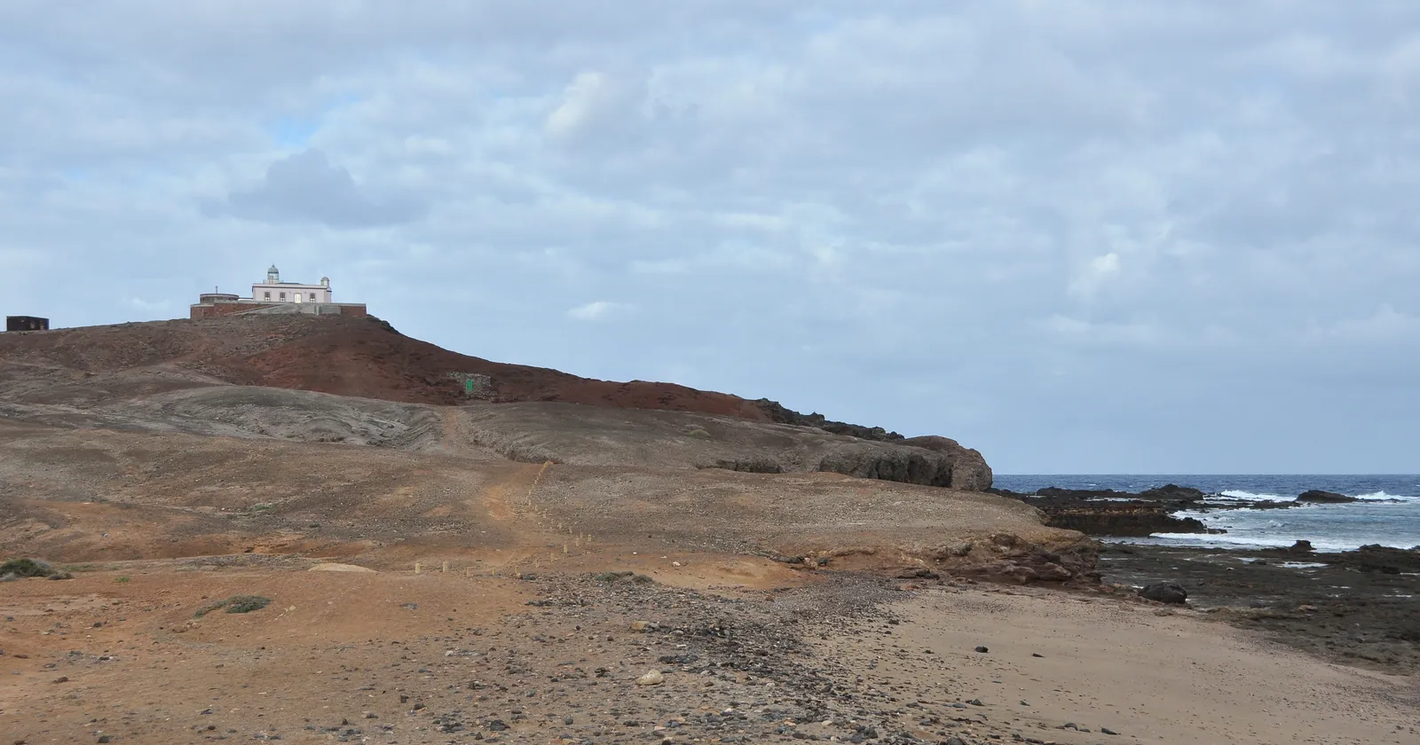 Punta de Arinaga and its old lighthouse above the rocky Agüimes shore, the headland divers head for on the way to El Cabrón, the best-known site for Gran Canaria diving