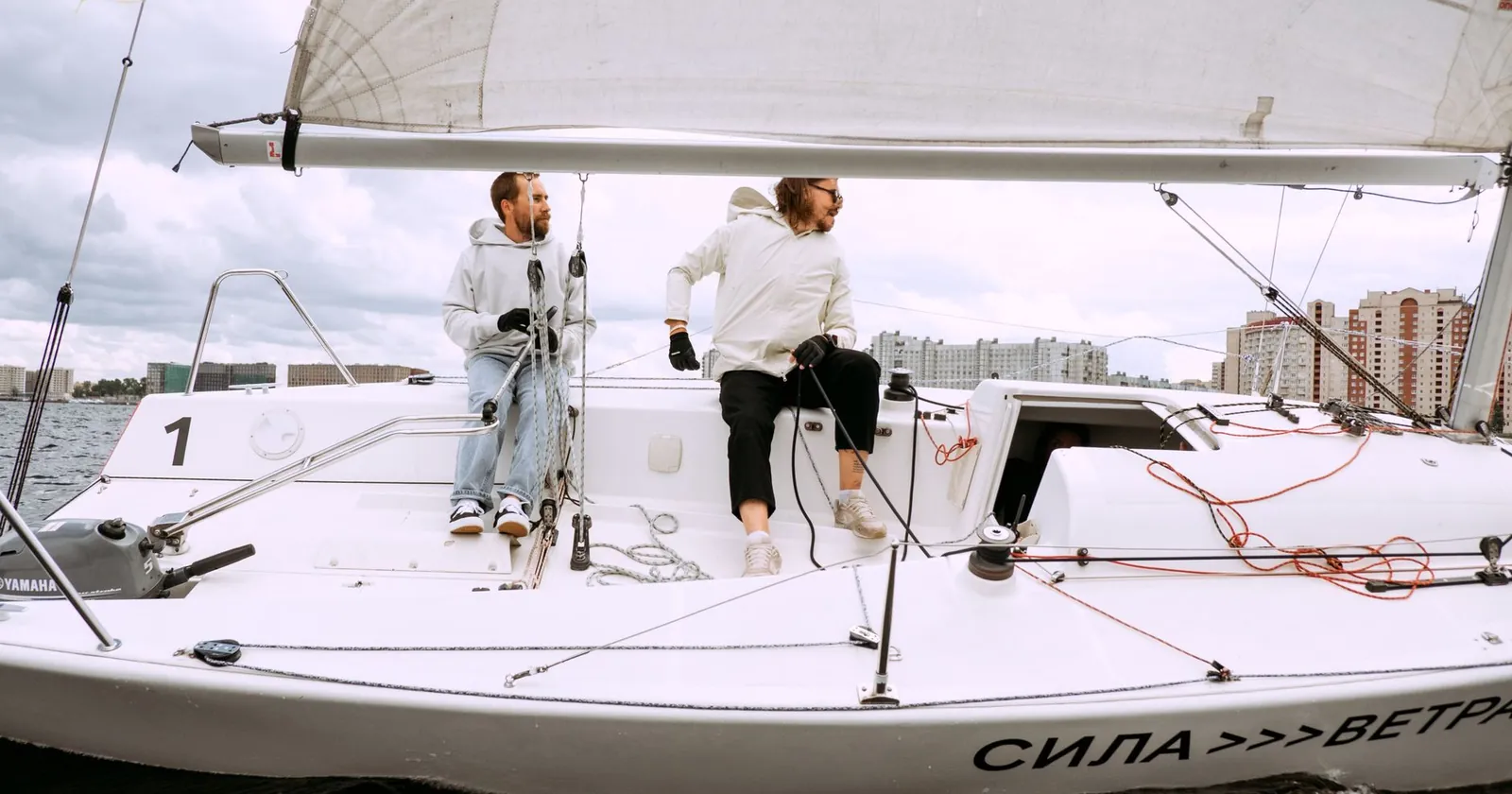 Crew working on the deck of a sailboat under sail