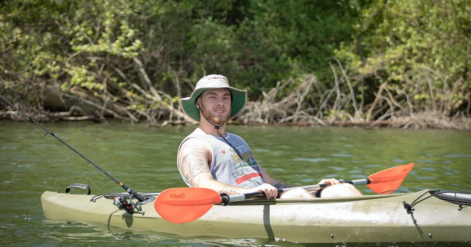 Kayak angler wearing a PFD with rods and tackle rigged