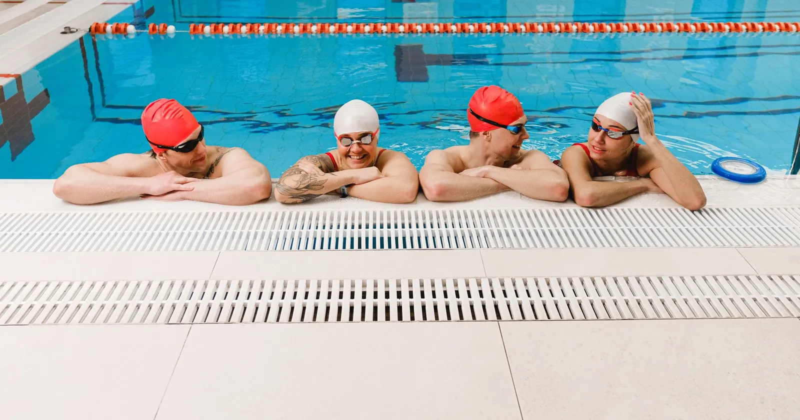 Swimmers in a group session with brightly coloured caps and tow floats