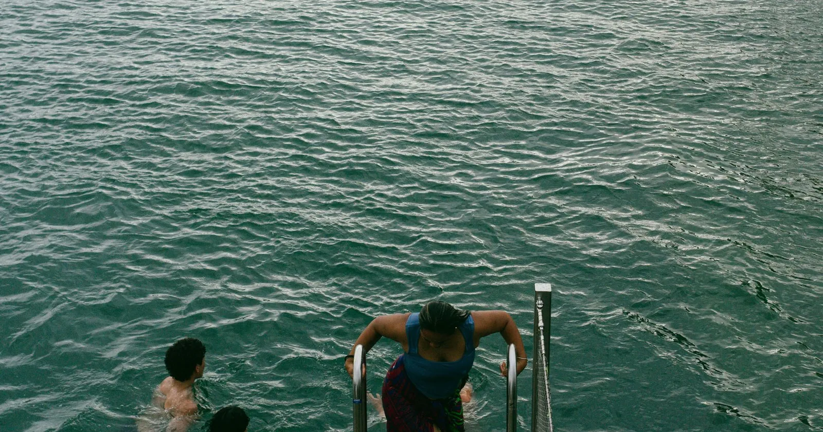 Open water swimmer in a lake at dawn with a tow float