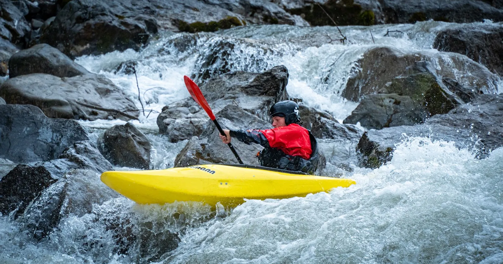 Kayaker rolling upright in whitewater