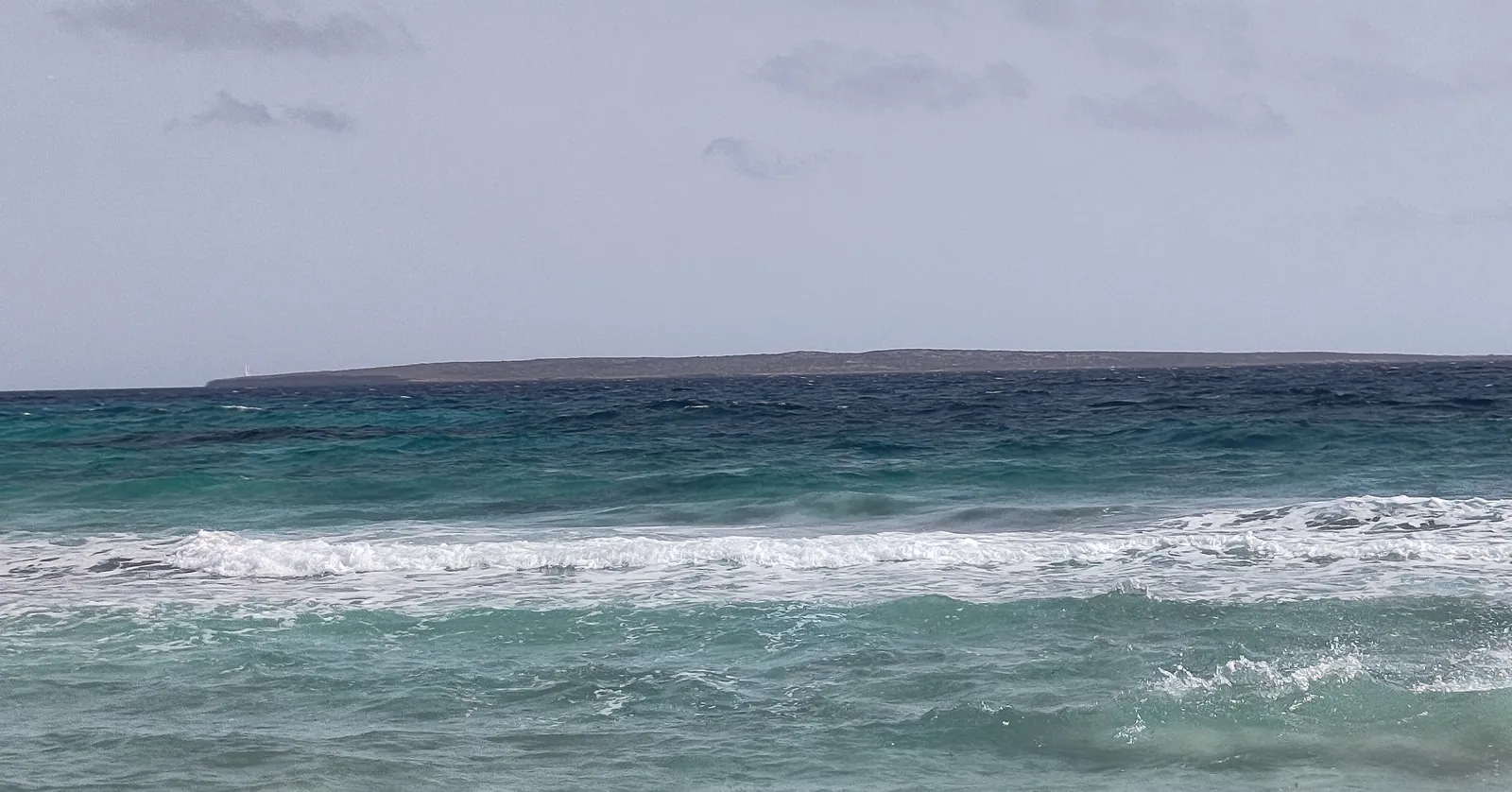 The low islet of s’Espardell on the horizon, seen from the Trucadors point of Formentera, where scuba is banned in the maximum protection zone of the Freus reserve used for Ibiza diving