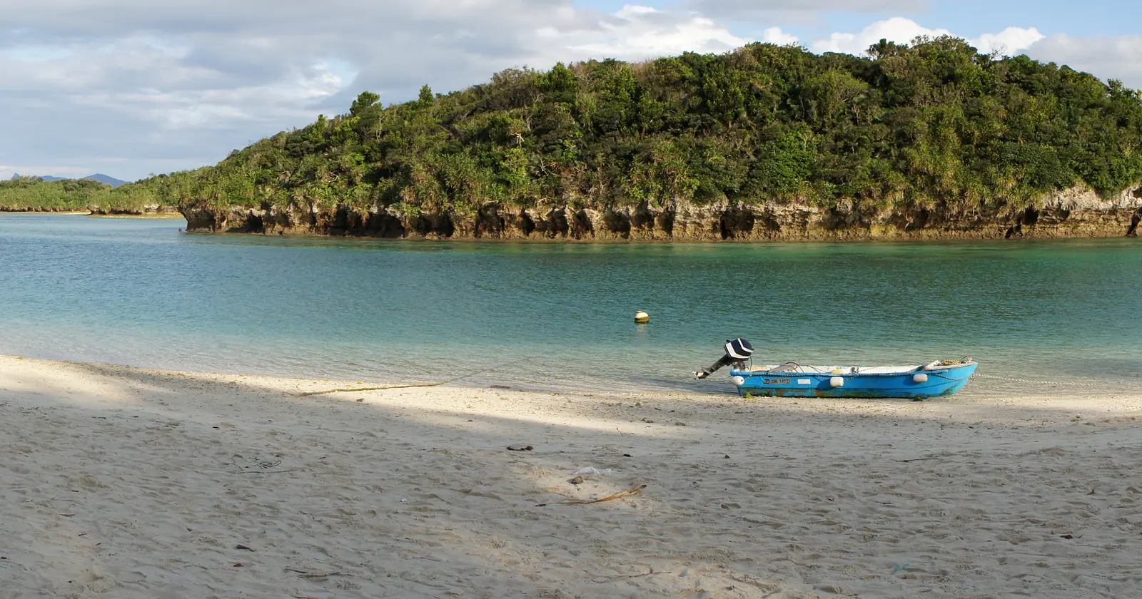 Kabira Bay on Ishigaki with its limestone islets and a small boat on the beach, the stretch of coast named in the Ishigaki diving manta rules