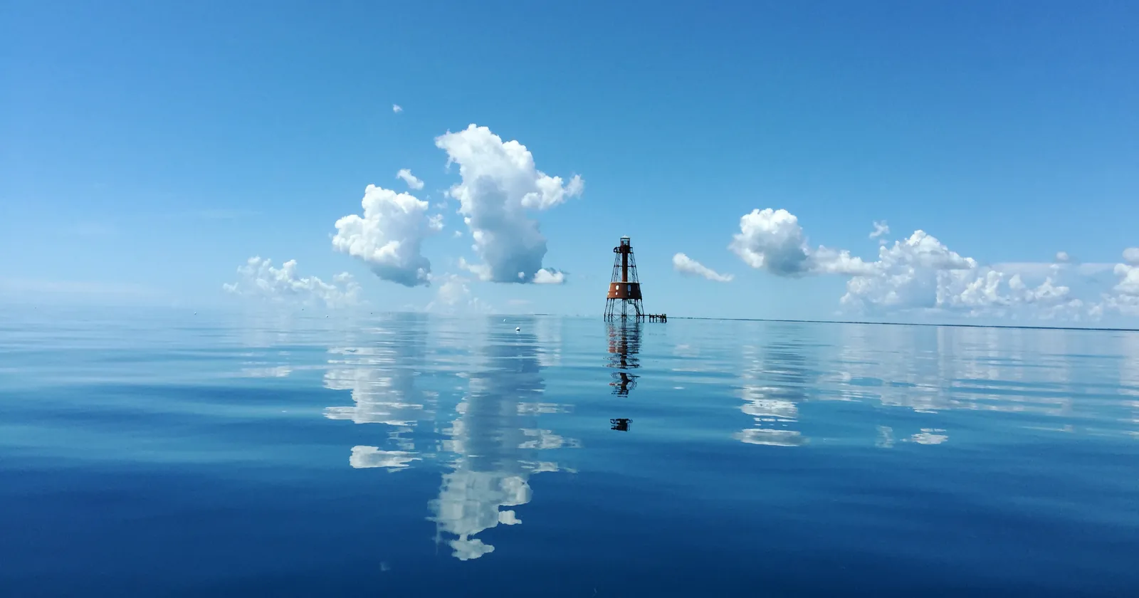 Carysfort Reef Lighthouse standing on the reef in flat calm water off Key Largo, a Key Largo diving site inside the Carysfort Sanctuary Preservation Area