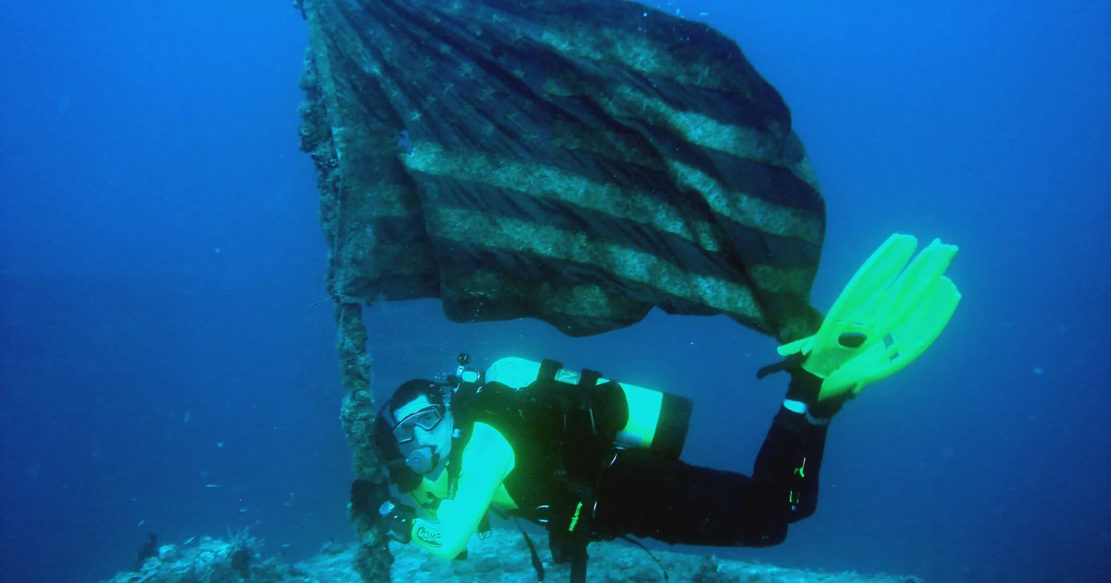 Scuba diver beside the US flag mounted on the deck of the Spiegel Grove wreck off Key Largo