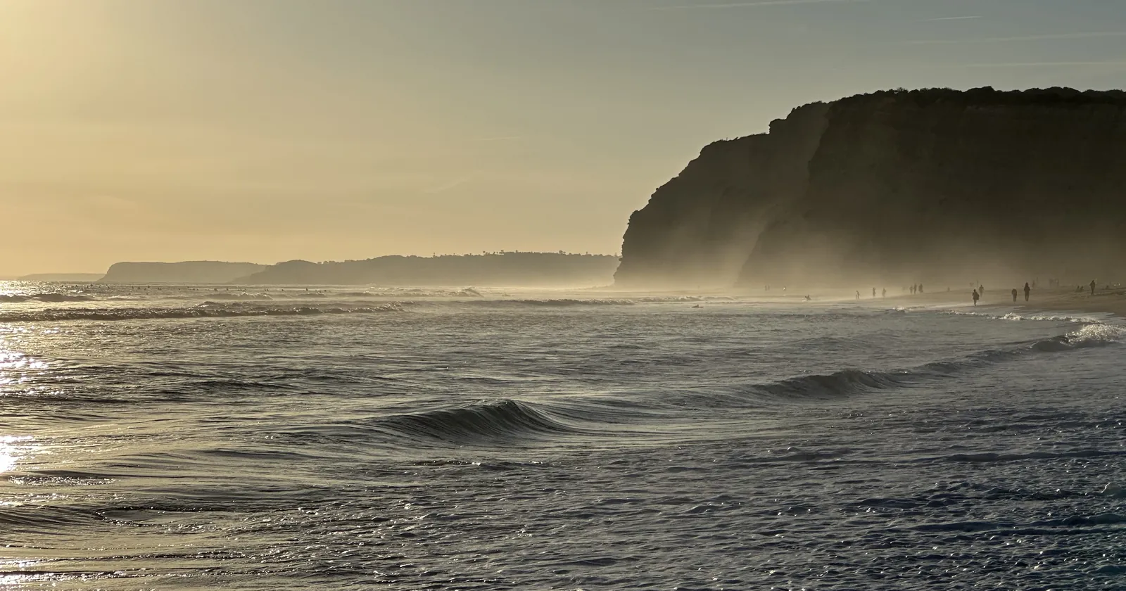 Waves rolling in at sunset near Porto de Mós beach in Lagos, one of the town's surf lesson beaches