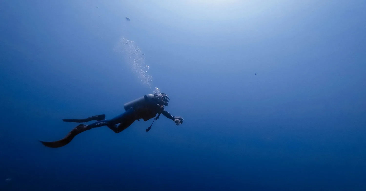 Clear Atlantic water over dark volcanic rock and black sand on the south coast of Lanzarote