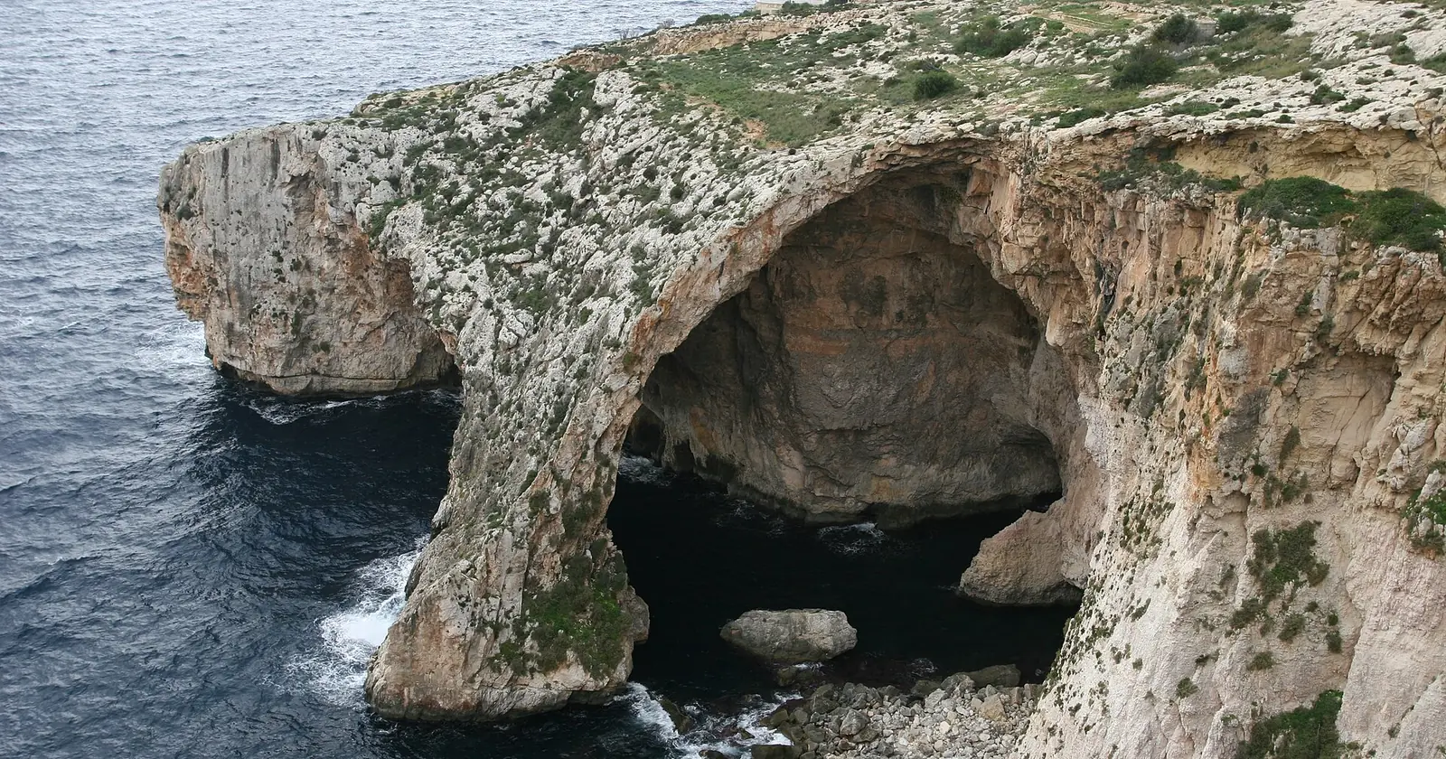 The Blue Grotto arch on Malta's south coast, with the sea running in under limestone cliffs