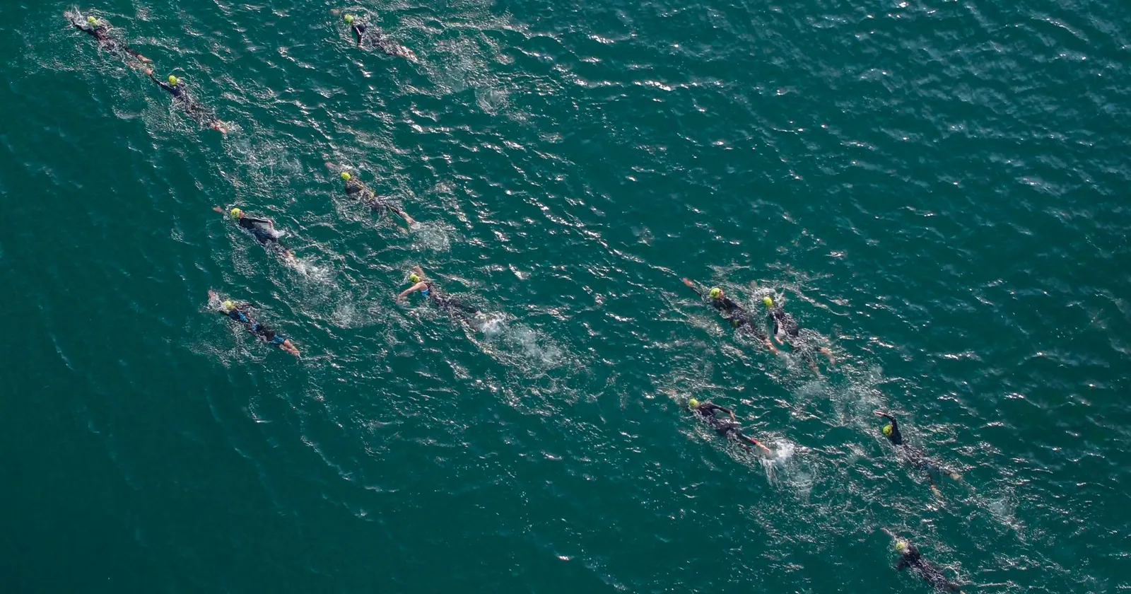 Swimmer putting on a swim-specific wetsuit by the water
