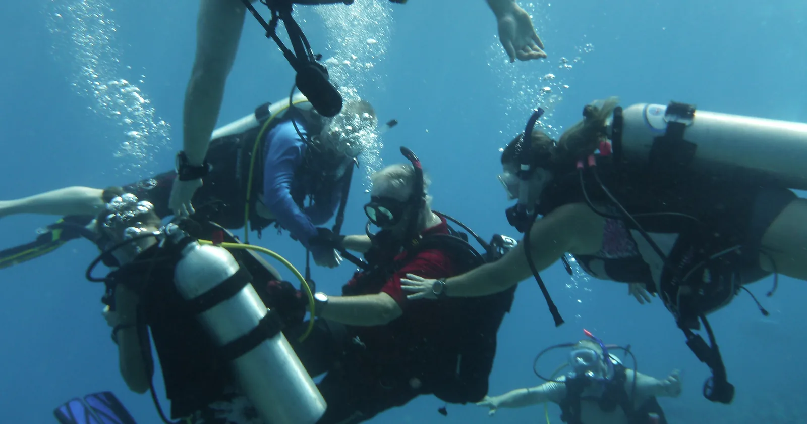 Scuba instructor guiding diving students underwater during a dive course, the training PADI and SSI both certify
