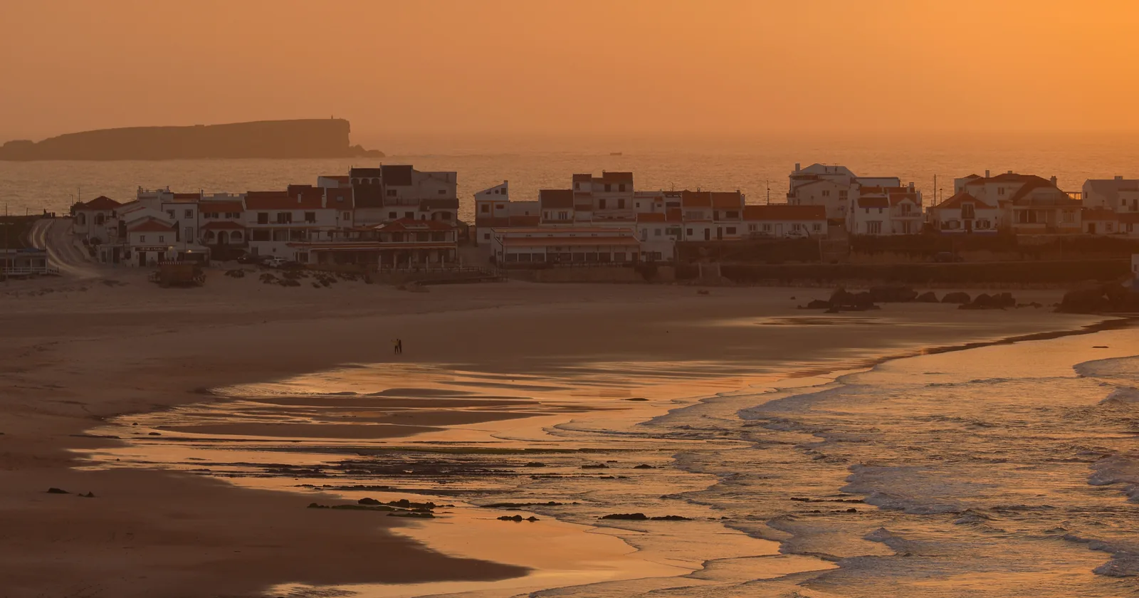 Praia Baleal Norte at Peniche, Portugal, at sunset, with the village on the headland behind a wide sand beach