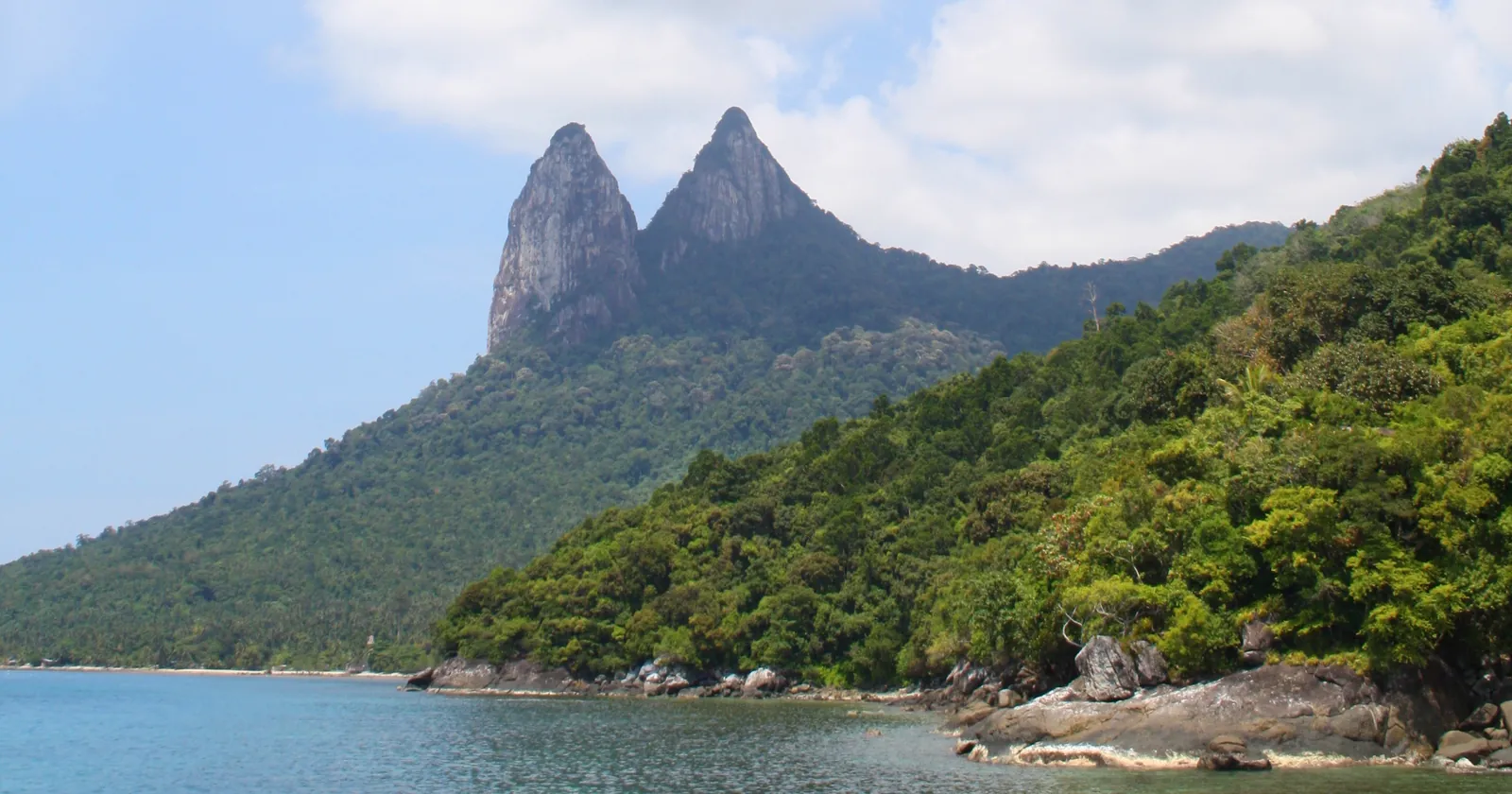 Twin granite peaks above the forested south coast of Tioman Island, seen from the sea