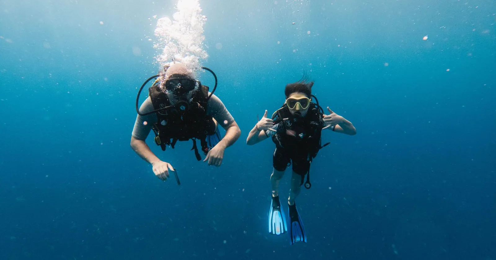 Two divers communicating with hand signals