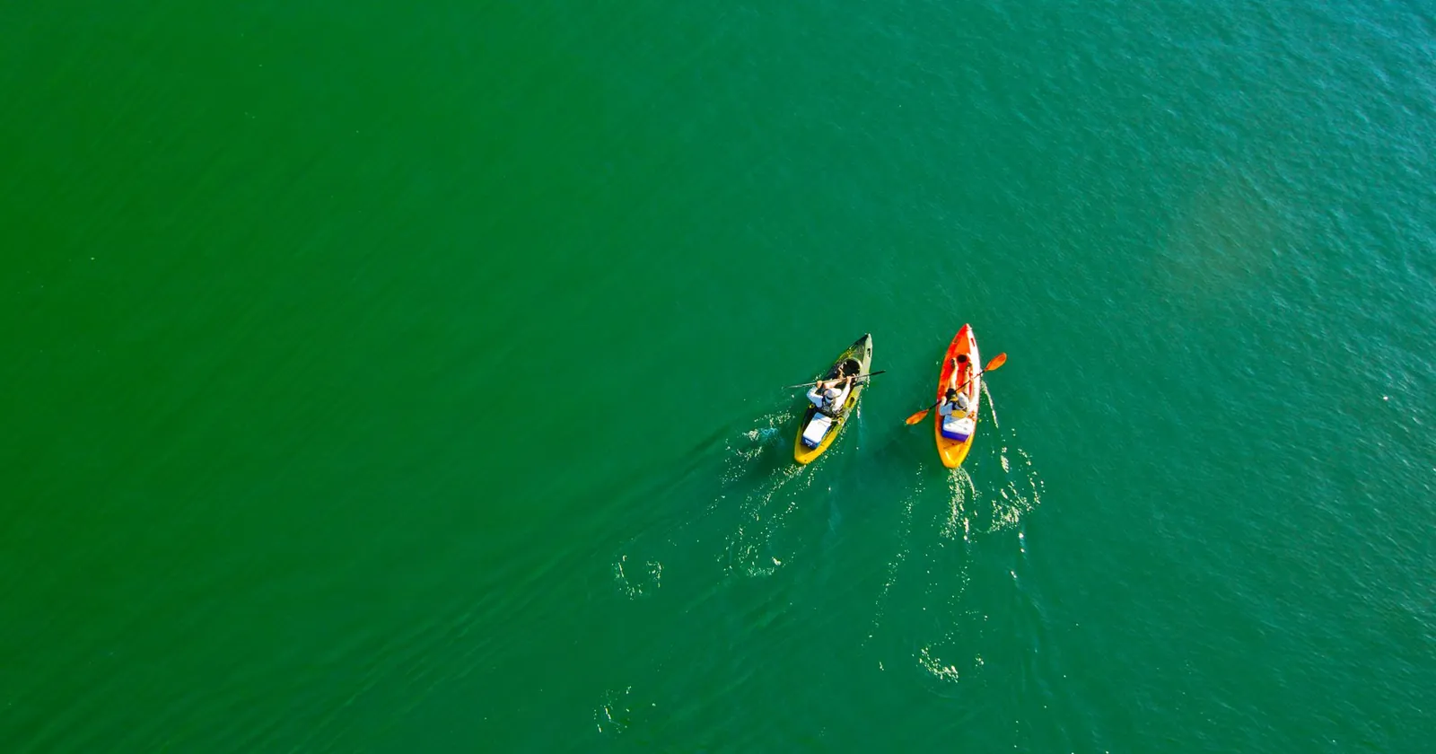 Paddleboard and kayak on calm water