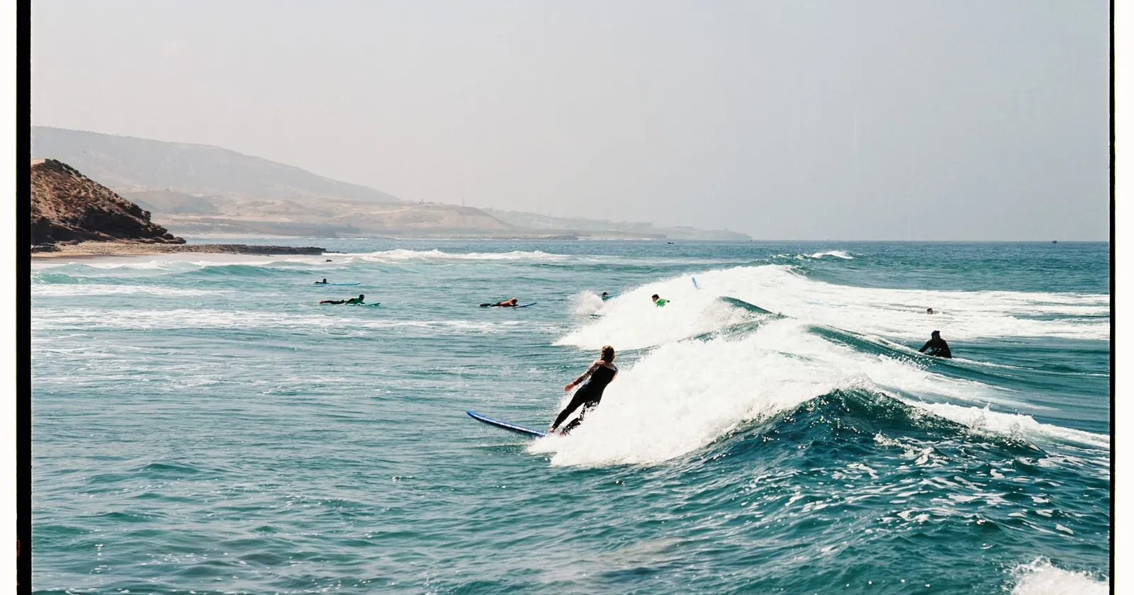 Surfers on a Moroccan point break at sunset