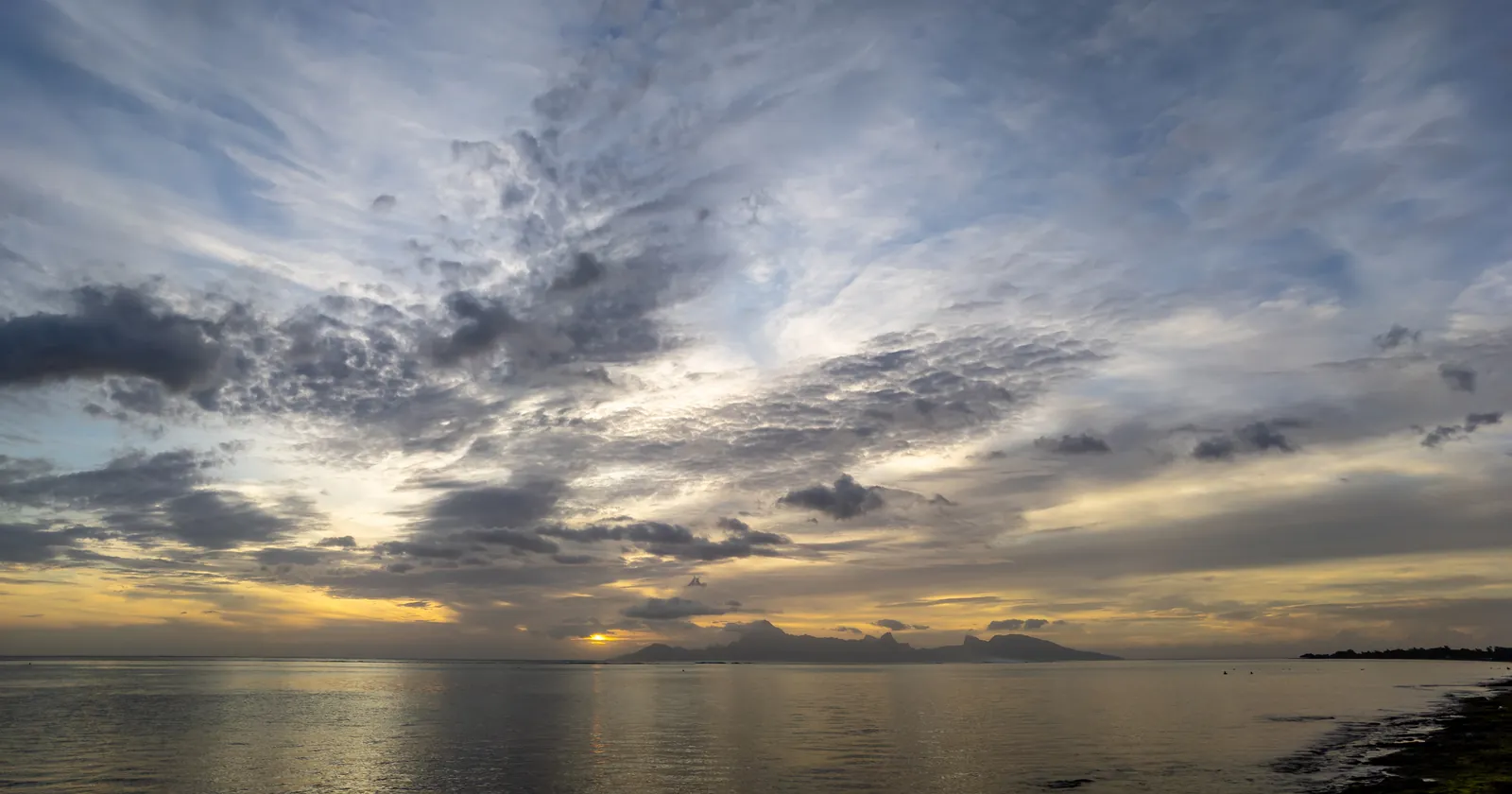 Evening over the lagoon at PK 18 beach in Punaauia on Tahiti's west coast, the shore where Tahiti diving boats leave from, with Moorea on the horizon across the channel