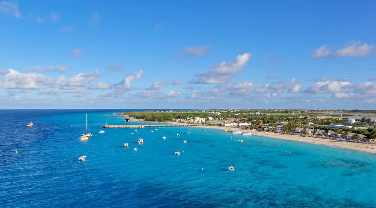 Dive and charter boats moored in turquoise water off Governor's Beach on Grand Turk, with deep blue water beyond, on the Turks side of Turks and Caicos diving