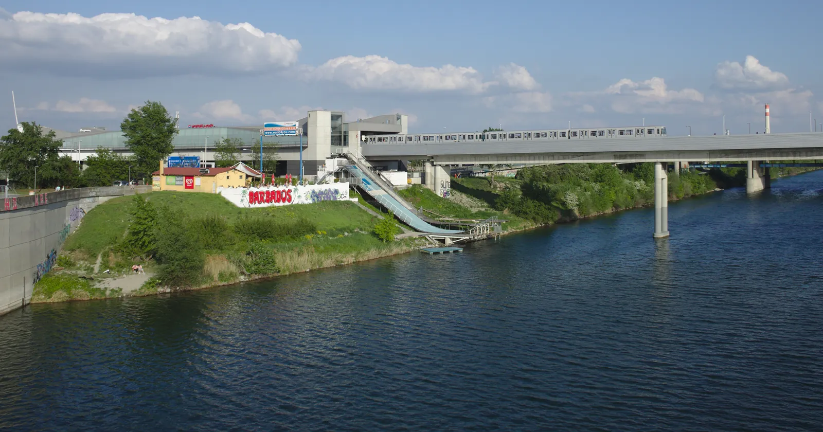 The Neue Donau at Vienna's 22nd district, with a U2 train crossing the Donaustadtbrücke and the station beside the water